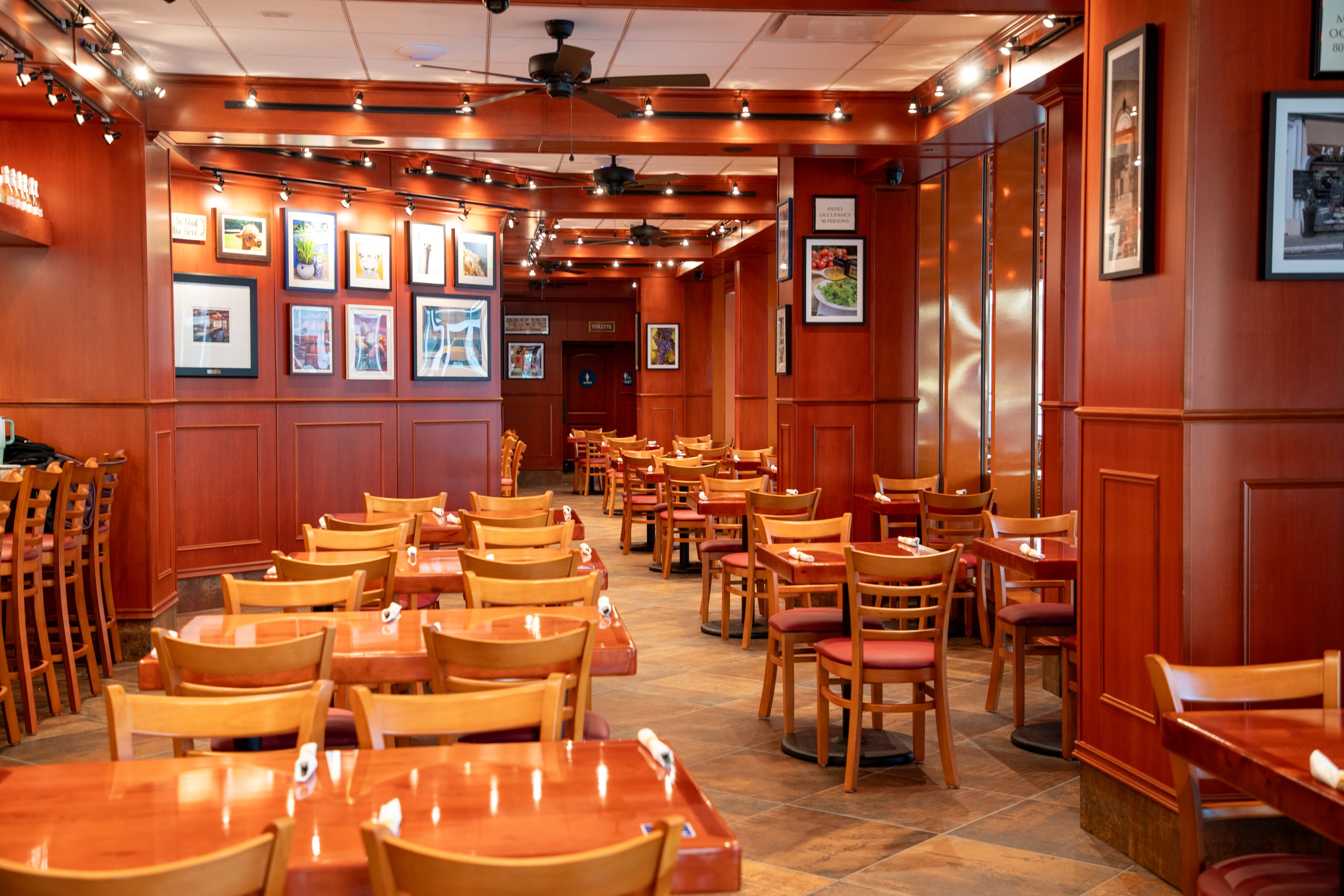 Warm and modern dining room interior at Panini Kabob Grill with wooden tables and cozy seating